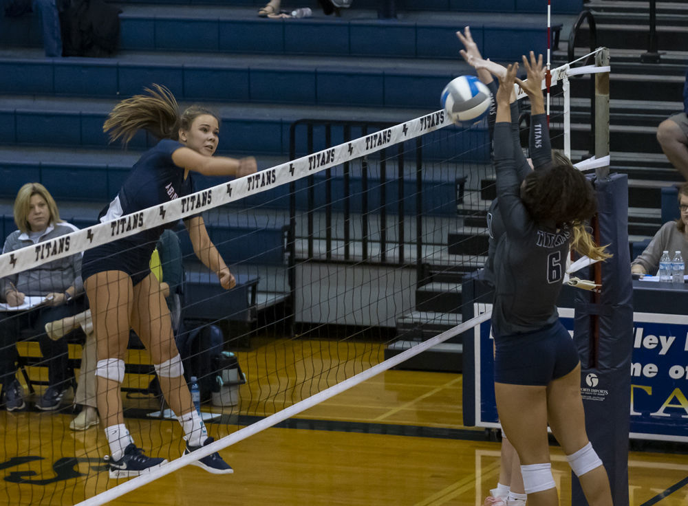 Abingdon's (9) Katie Harless tries to spike the ball through Hidden Valley's (6) Leilani Pickens and teammate.